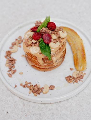 a dessert on a plate with a banana and strawberries at Surf & Party - Hostel Somewhere Else in Canggu