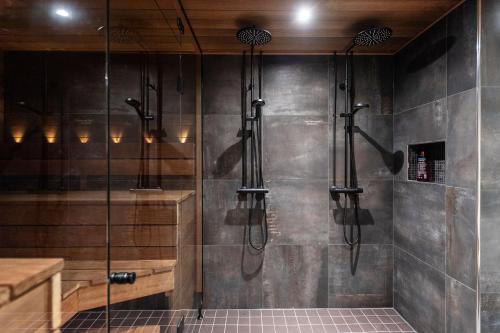 a shower in a bathroom with a wall at Chalé NAAVA in Rukatunturi 