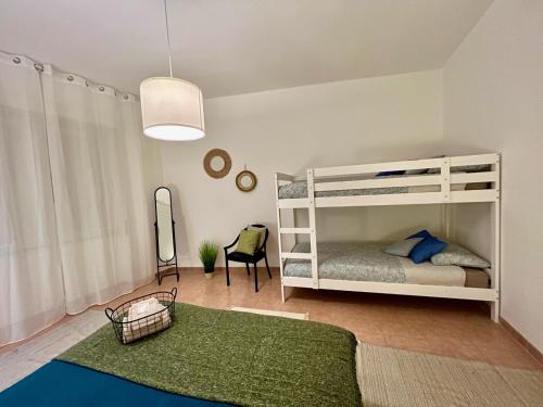 a bedroom with two bunk beds and a green rug at Stay in Malpensa in Case Nuove