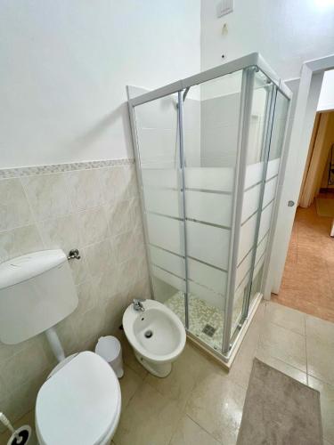 a bathroom with a toilet and a glass shower at Stay in Malpensa in Case Nuove