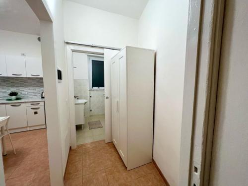 uma casa de banho com um armário branco numa cozinha em Stay in Malpensa em Case Nuove