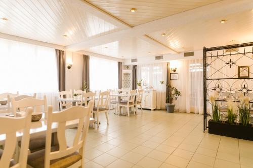 a dining room with white tables and chairs at Villa Helvetia in Târgu-Mureş