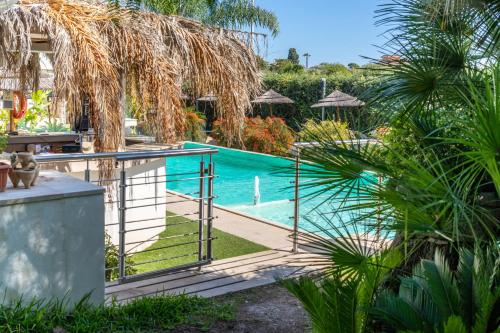 a pool with a fence next to a house at Saija Attico in Pozzallo