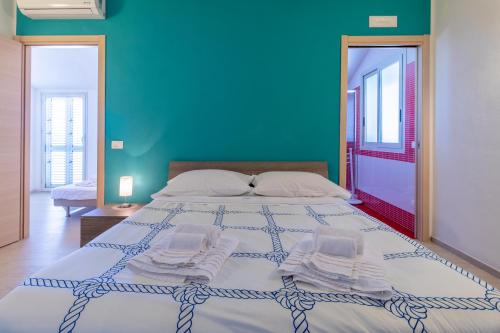 a bedroom with a large bed with a blue wall at Saija Attico in Pozzallo