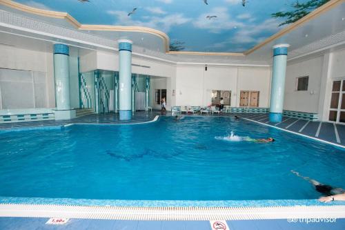 a person swimming in a large swimming pool at Golf Residence- Families and Couples Only in Hammam Sousse