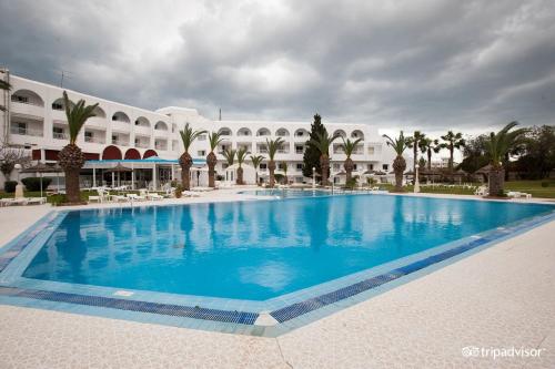 a large swimming pool in front of a building at Hotel Golf Residence in Hammam Sousse