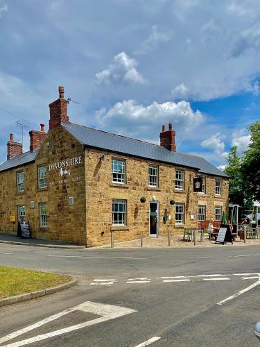 an old brick building on the side of the road at The Devonshire Arms in Eckington