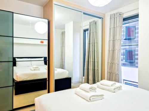 een slaapkamer met 2 bedden en een spiegel bij Pass the Keys The perfect stay in Londen