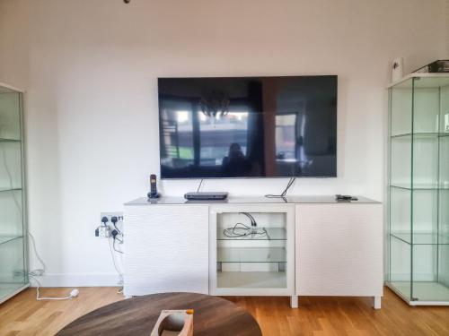 een wit bureau met een tv aan de muur bij Pass the Keys The perfect stay in Londen