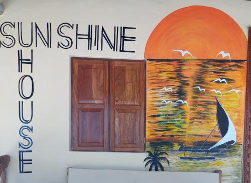 a sign on the side of a building with a painting at A Villa Sunshine house Zanzibar in Jambiani