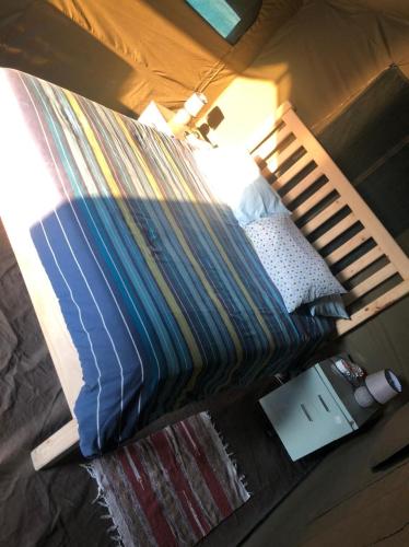 a bed with a striped comforter in a bedroom at Kruger Ranch in Magaliesburg