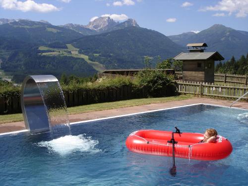 a child in an inflatable raft in a swimming pool at nawu apartments & Restaurant in Hermagor