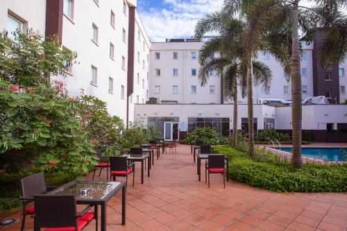 a row of tables and chairs next to a building at Ibis Lagos Airport in Ikeja