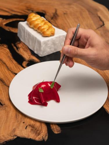 a person eating a piece of food on a white plate at MUSA Lago di Como in Sala Comacina