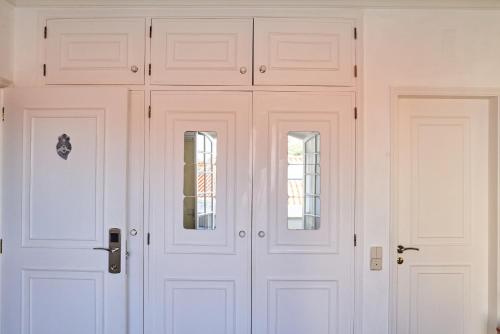 two white doors in a white walled room at Ljmonade Hostel in Cascais