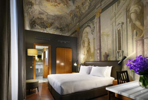 Schlafzimmer mit einem Bett und einer Decke mit Gemälden in der Unterkunft Hotel Garibaldi Blu - WTB Hotels in Florenz