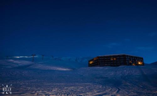 a building in the snow at night at New Gudauri Atrium apartment #233 in Gudauri