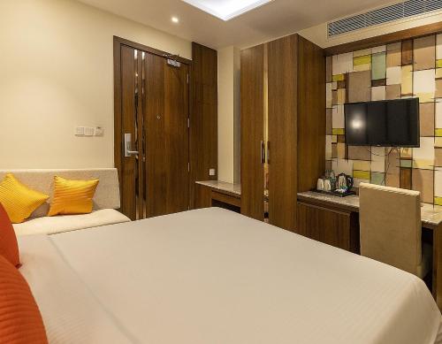 a hotel room with a bed and a tv at Brio Hotel in Kolkata