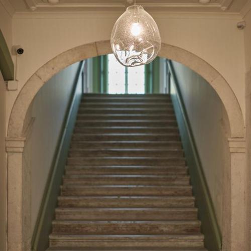 a hallway with a staircase with a chandelier and a stairwayngthngth at Look Living, Lisbon Design Apartments in Lisbon