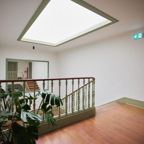 a room with a staircase with a skylight and a plant at Look Living, Lisbon Design Apartments in Lisbon