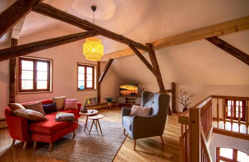 sala de estar con sofá rojo y sillas en Ferienwohnung Bolbritz en Bautzen