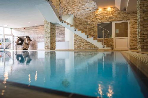 an indoor swimming pool with a brick wall at Familotel Alphotel in Hirschegg