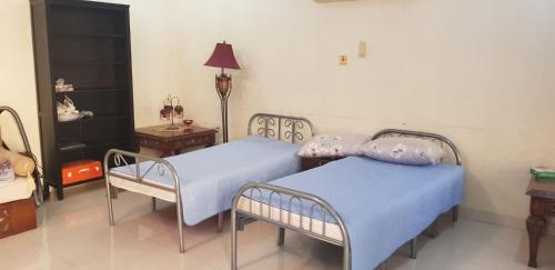 ein Schlafzimmer mit 2 Betten, einem Tisch und einer Lampe in der Unterkunft Family Environmental Studio/مجلس خارجي بفيلا سكنية 