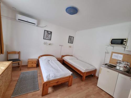ペーチにあるHungaria Apartmentsのベッドとキッチン付きの病室です。