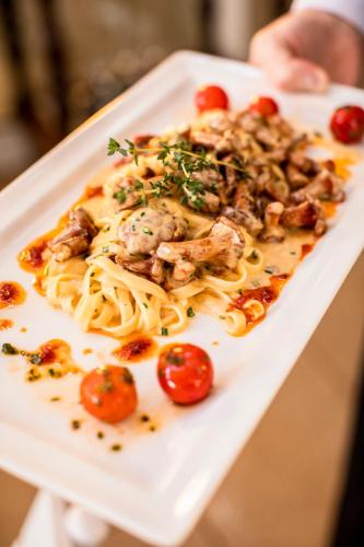 a plate of pasta with chicken and tomatoes on it at Insel-Hotel Heilbronn in Heilbronn