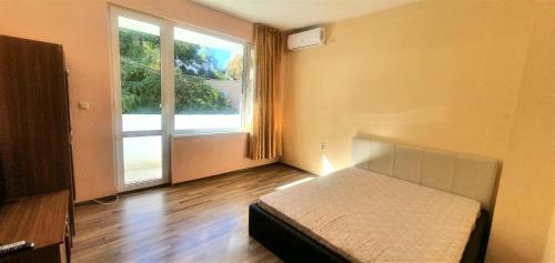 a bedroom with a bed and a large window at Стаи, студиа и апартаменти in Svishtov