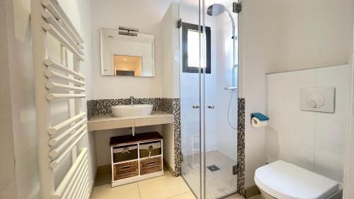 een badkamer met een douche, een wastafel en een toilet bij Villa Santa Giulia, vue panoramique sur la mer, 900 m de la plage in Porto-Vecchio