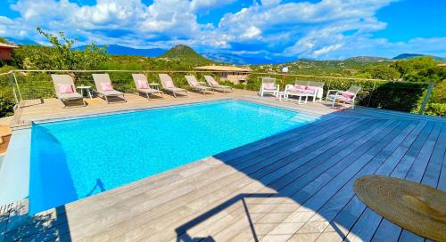 une piscine avec des chaises et une terrasse avec dans l'établissement Villa Santa Giulia, vue panoramique sur la mer, 900 m de la plage, à Porto-Vecchio
