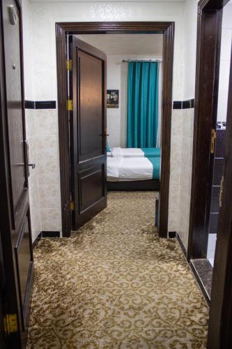 a hallway with a door open to a room with a bed at The Castle Hotel in Amman