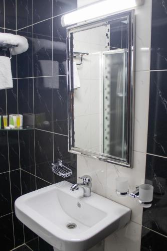 a bathroom with a sink and a mirror at The Castle Hotel in Amman