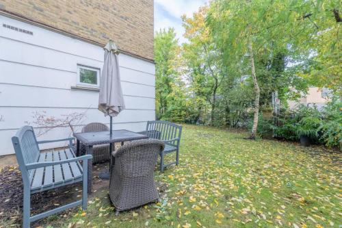 a patio with a table and chairs and an umbrella at Spacious 2 Bedroom Flat in Wandsworth in London