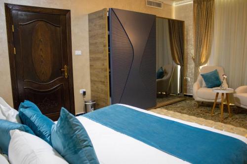 a hotel room with a large bed with blue pillows at The Castle Hotel in Amman
