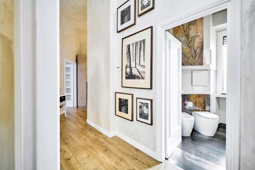 a white hallway with pictures on the wall at Appartamento a uso turistico in Viterbo