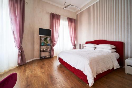 a bedroom with a large bed with a red headboard at Appartamento a uso turistico in Viterbo