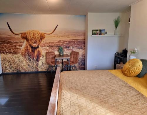 a bedroom with a large mural of a cow at De Schotse Hooglander in Smilde