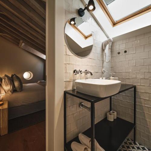 a bathroom with a sink and a mirror and a bed at Look Living, Lisbon Design Apartments in Lisbon