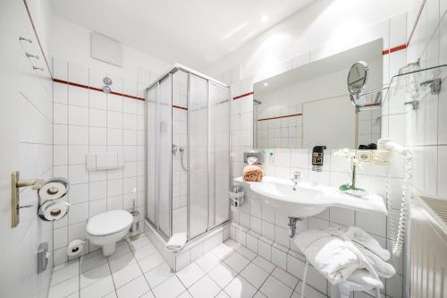 ein Bad mit einem WC, einem Waschbecken und einer Dusche in der Unterkunft Hotel Sportwelt Radeberg in Radeberg