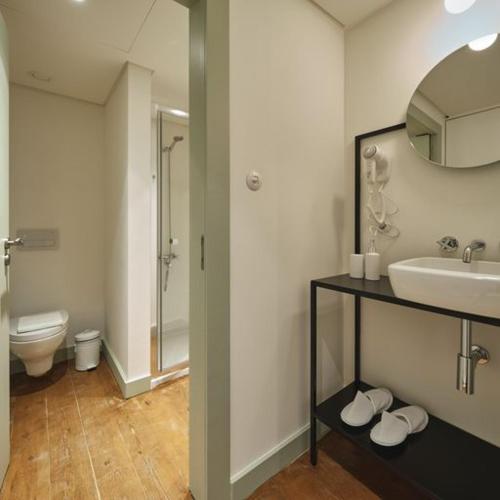 a bathroom with a sink and a toilet and a mirror at Look Living, Lisbon Design Apartments in Lisbon