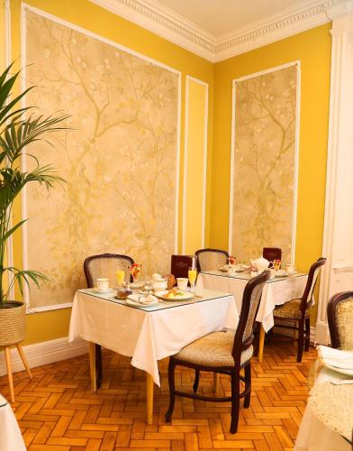 a dining room with two tables and chairs and a painting at Kilronan House in Dublin