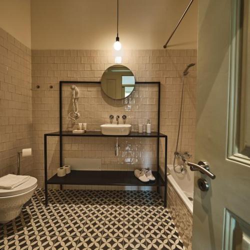 a bathroom with a sink and a toilet and a mirror at Look Living, Lisbon Design Apartments in Lisbon