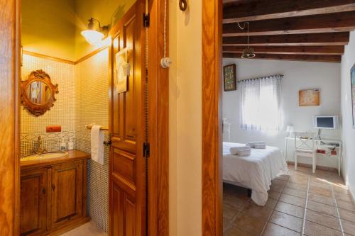 a bathroom with a sink and a bed in a room at Vinarius, Posada Rural in Castellanos de Villiquera