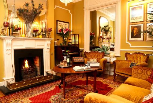 a living room with a fireplace and a table at Kilronan House in Dublin