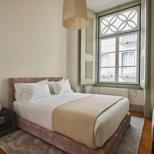 a bedroom with a large bed and two windows at Look Living, Lisbon Design Apartments in Lisbon