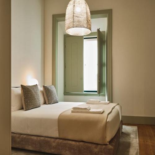 里斯本Look Living, Lisbon Design Apartments的一间卧室设有一张大床和大窗户