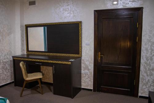 a room with a desk with a television and a door at The Castle Hotel in Amman