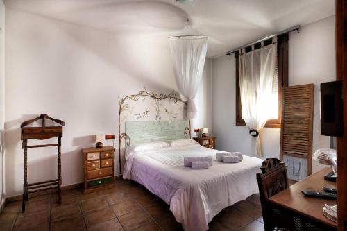 a bedroom with a bed with a white bedspread at Vinarius - Exclusiva Posada Rural con cava romana del siglo III y manantial in Castellanos de Villiquera